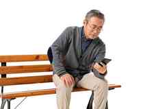 坐在长椅上的老人看手机