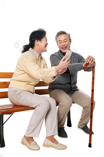 老年夫妇坐在长椅上看手机