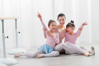 年轻舞蹈教师和小女孩高举手臂场景