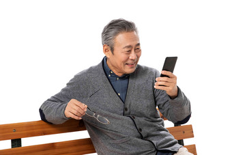 坐在长椅上的老人看手机