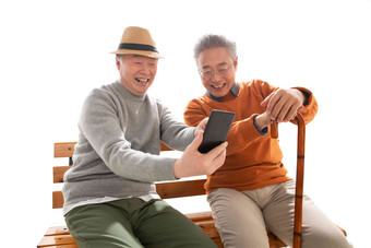 两位老年朋友坐在长椅上看<strong>手机</strong>