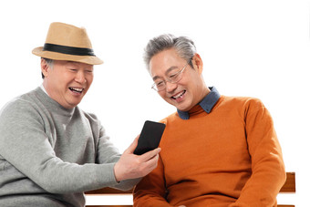 两位老年朋友坐在长椅上看手机聊天高清相片