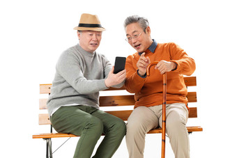 两位老年朋友坐在长椅上看<strong>手机</strong>快乐高质量相片