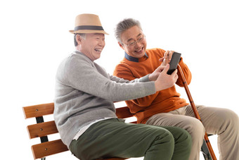 两位老年朋友坐在长椅上看手机幸福高清照片