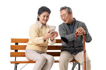 <strong>老年</strong>夫妇坐在长椅上看手机