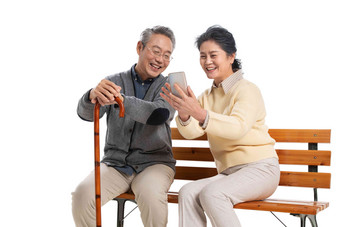 老年夫妇坐在长椅上看<strong>手机</strong>