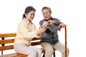 老年夫妇坐在长椅上看<strong>手机</strong>