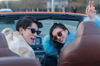 时尚的青年伴侣驾驶跑车兜风