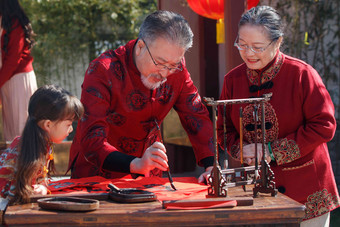 祖父母和孙女三人一起写<strong>福字</strong>