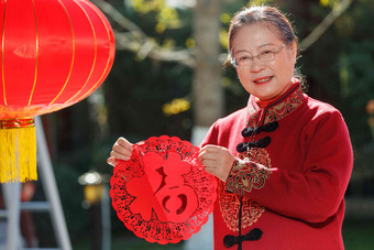 老年女人手拿窗花庆祝新年