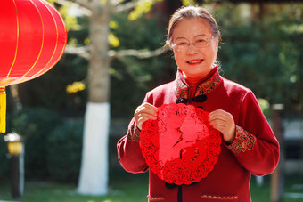 老年女人手拿窗花庆祝新年