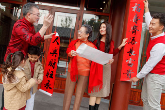 幸福的大家庭贴春联庆祝新年