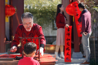 幸福家庭<strong>写春联</strong>庆贺新年中式庭院氛围拍摄