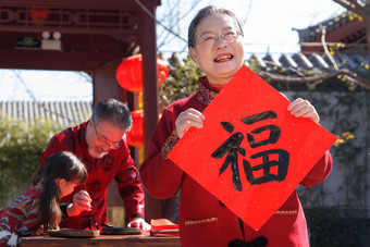 祖父母和孙女三人一起写福字