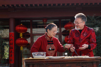 幸福的老年夫妇过年包饺子四合院高清图片