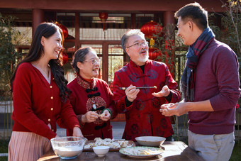 幸福的家庭过年包饺子拿着高清拍摄图片