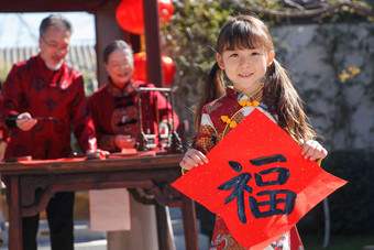 祖父母和孙女三人一起写福字写氛围摄影