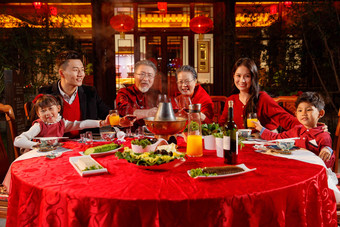 东方家庭在中式庭院内干杯庆祝新年聚餐写实相片