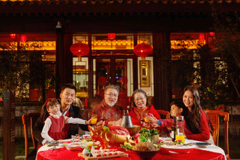 东方家庭在中式庭院内干杯庆祝新年祝福高质量图片