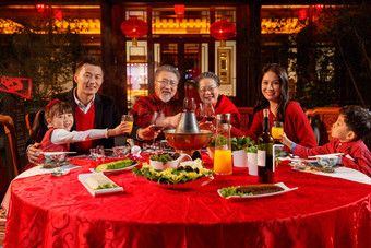 东方家庭在中式庭院内干杯庆祝新年聚餐写实影相