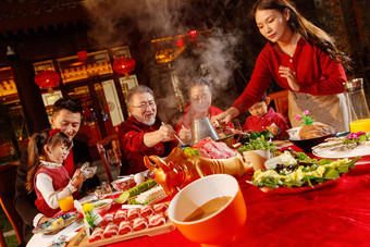 春节东方家庭在中式庭院内聚餐六个人摄影图