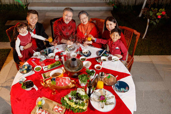 春节东方家庭在中式庭院内聚餐成年人高清摄影图
