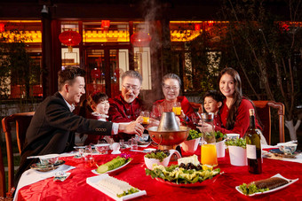 东方家庭在中式庭院内干杯庆祝<strong>新年</strong>父亲高清相片