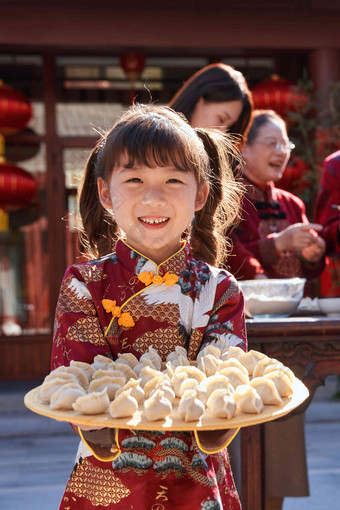 可爱的小女孩端着饺子