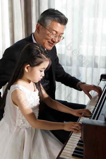 祖父和孙女一起弹钢琴表演高清摄影图