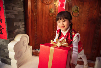 <strong>拜年</strong>的可爱小女孩拿着礼品盒中国写实相片