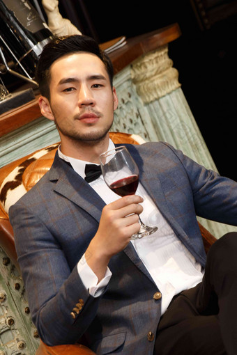 青年男人拿着红葡萄酒杯传统高质量相片