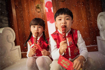 吃冰糖葫芦的可爱男孩女孩传统节日摄影图