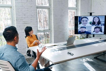 商务男女在会议室开视频会议显示器镜头