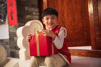 可爱的小男孩抱着礼品盒传统服装氛围素材