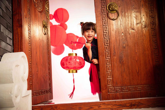漂亮的小女孩手提红灯笼庆祝新年