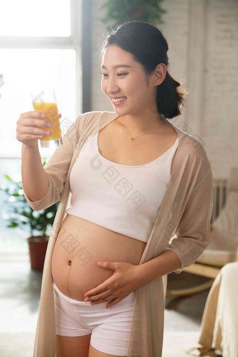 孕妇正在喝果汁腹部高质量摄影