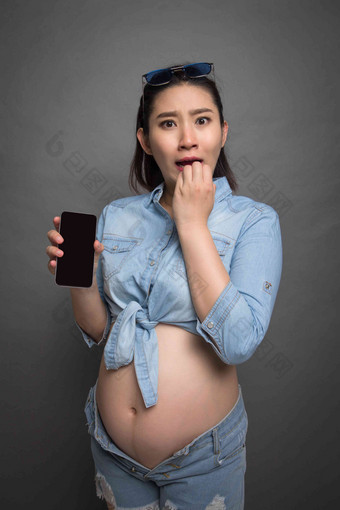 穿着时尚的孕妇拿着手机休闲装高清照片
