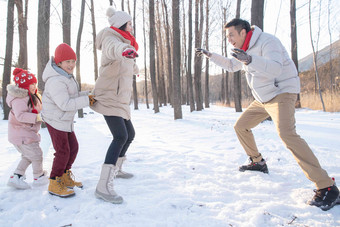 雪地里做游戏的快乐家庭夫妇氛围摄影图