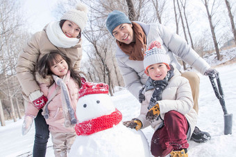 欢乐家庭在雪地里堆雪人