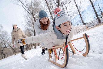 在<strong>雪地</strong>上玩雪橇的一家人中年男人清晰照片