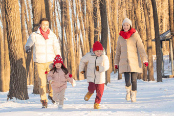 欢乐家庭在雪地里奔跑寒冷的写实相片