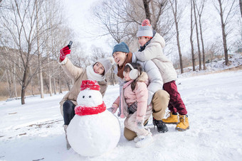 欢乐家庭在雪地里堆雪人夫妇照片