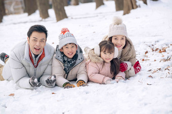 趴在雪地里玩耍的快乐家庭寒冷的高清拍摄