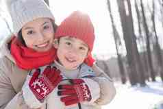 年轻妈妈带着孩子在雪地玩耍