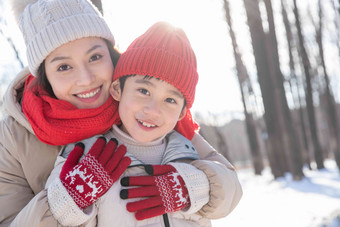 年轻妈妈带着孩子在雪地玩耍青年人高质量影相
