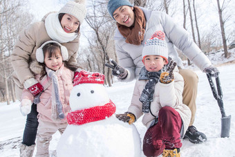 欢乐家庭在雪地里堆雪人