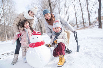 欢乐家庭在雪地里堆雪人