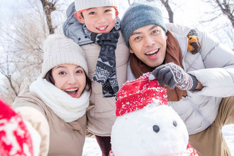 一家三口在雪地里堆雪人