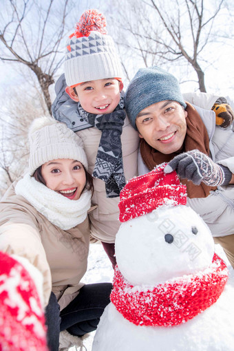 一家三口在雪地里<strong>堆雪人</strong>