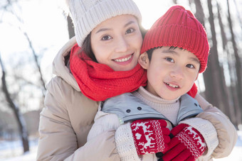 年轻妈妈带着孩子在雪地玩耍彩色图片高质量镜头